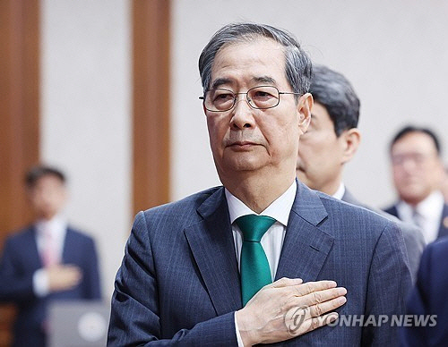 한덕수 대통령 권한대행 국무총리가 18일 정부서울청사에서 열린 국무회의에서 국기에 경례하고 있다.  [대통령실통신사진기자단=연합뉴스]